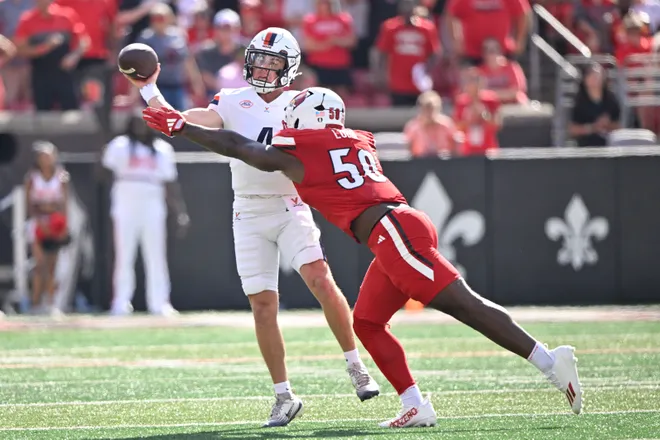 Oct 4, 2025; Louisville, Kentucky, USA; Virginia Cavaliers quarterback Chandler Morris (4) looks to pass against Louisville Cardinals defensive lineman Clev Lubin (50) during the first quarter at L & N Federal Credit Union Stadium. Mandatory Credit: Jamie Rhodes-Imagn Images