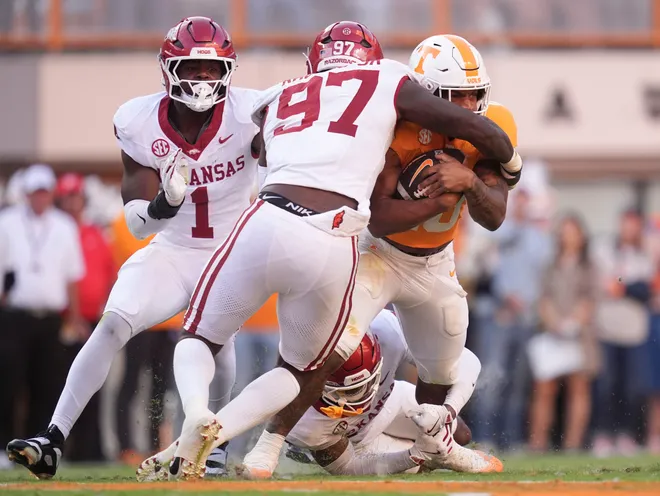 Tennessee running back DeSean Bishop (18) is stopped by Arkansas defensive lineman Quincy Rhodes Jr. (97) in an NCAA college football game on Oct. 11, 2025, in Knoxville, Tennessee.