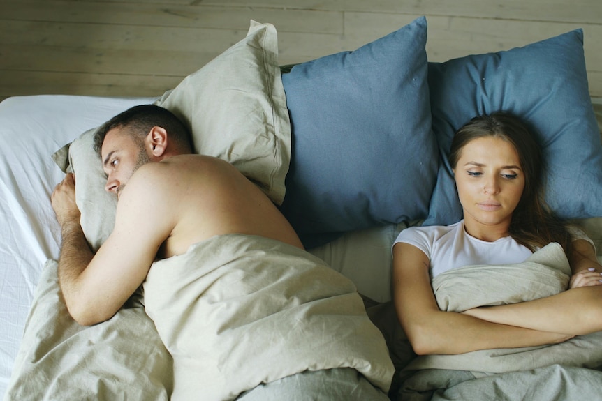 couple in bed turned away from each other