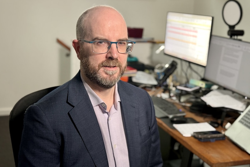 Man in glasses and suit.