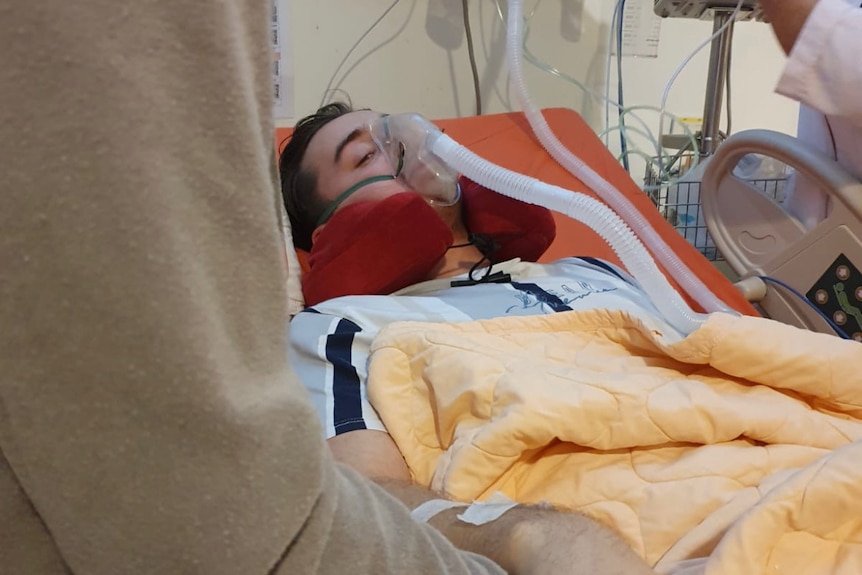 a young man in a hospital bed