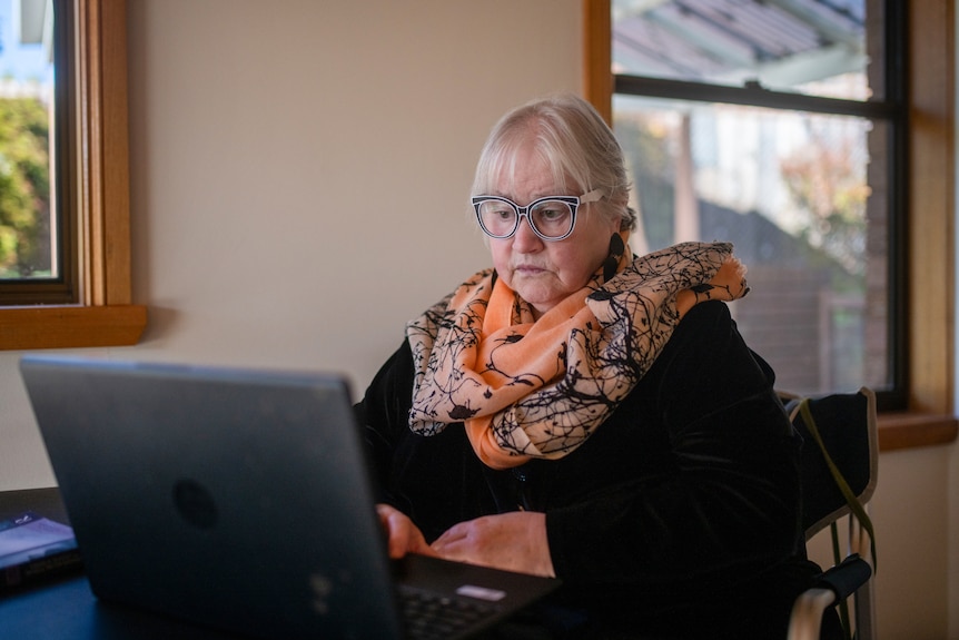 Dr Morag MacSween sits behind her desk with a laptop open