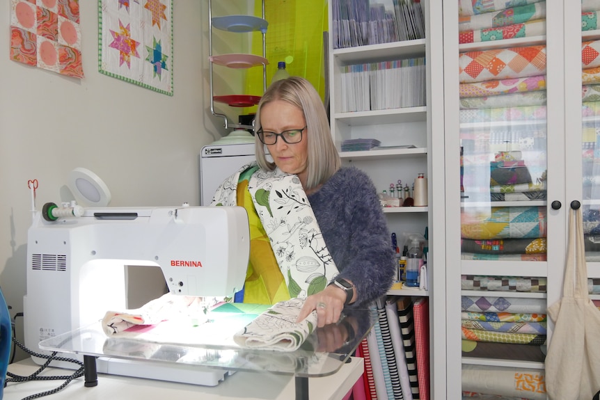 A woman is working on a quilt