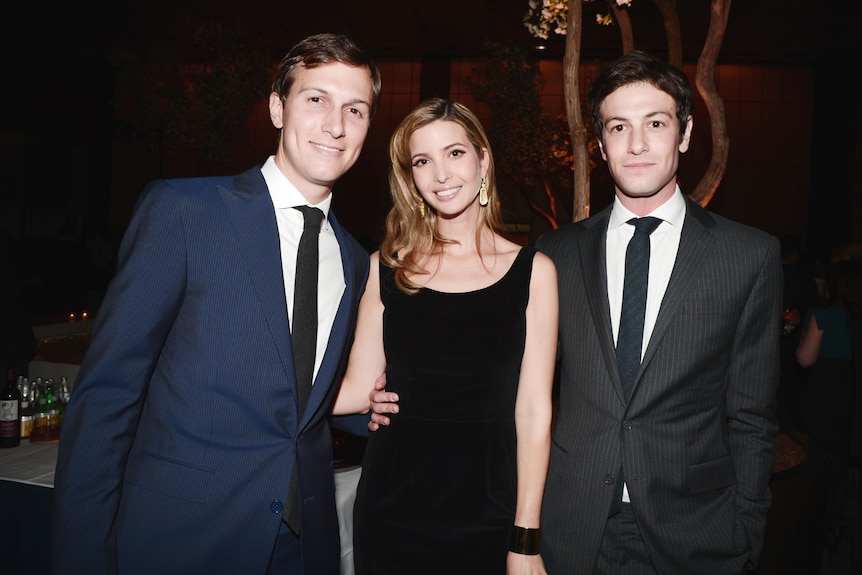 Two men and a woman are pictured together at an event.