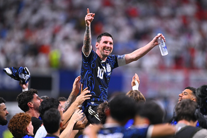 Lionel Messi is tossed into the air by teammates