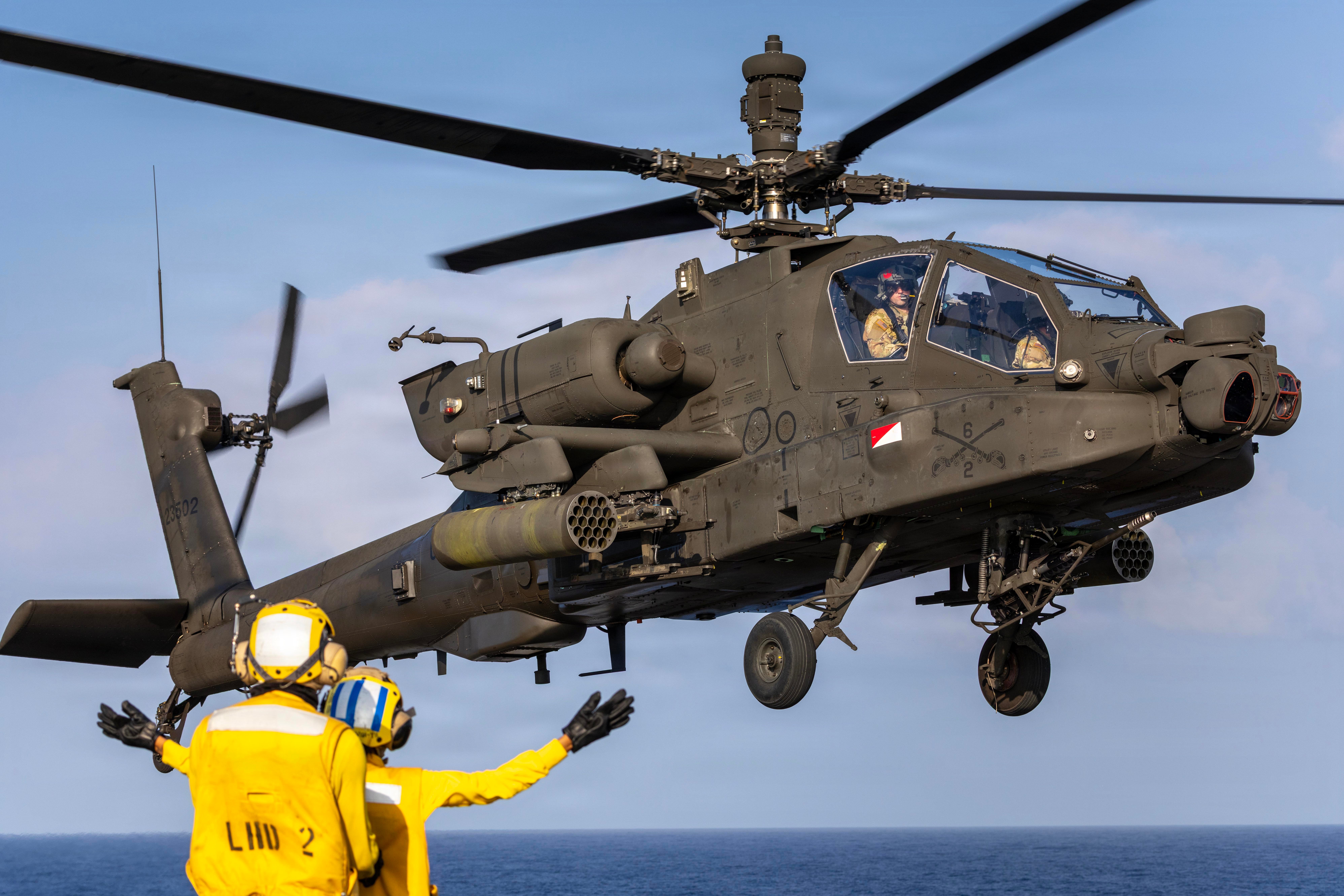 A U.S. Army AH-64 Apache helicopter assigned to 25th Combat Aviation Brigade, 25th Infantry Division, prepares to land while being directed in by a U.S. Navy Aviation Boatswain’s Mate, assigned to the handling team aboard the Wasp-class amphibious assault ship USS Essex (LHD 2), as part of Exercise Rim of the Pacific 2026 in the Pacific Ocean, July 19, 2026. Thirty nations, 30 ships, five submarines, 15 national land forces, more than 190 aircraft and more than 30,000 personnel are participating in RIMPAC in and around the Hawaiian Islands, June 24 to July 31. The world's largest international maritime exercise, RIMPAC provides a unique training opportunity while fostering and sustaining cooperative relationships among participants critical to ensuring the safety of sea lanes and security on the world's oceans. RIMPAC 2026 is the 30th exercise in the series that began in 1971. (U.S. Army photo by Sgt. Olivia Cowart)