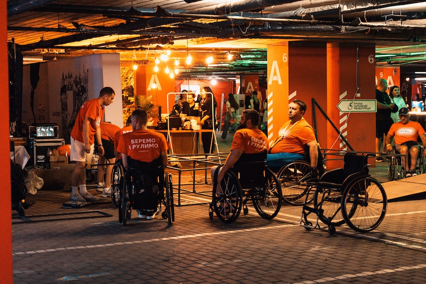 A group of men sit in wheelchairs.