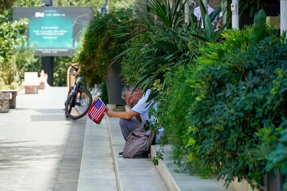 A flag vendor rests in the shade during high temperatures in Albania on June 30 .