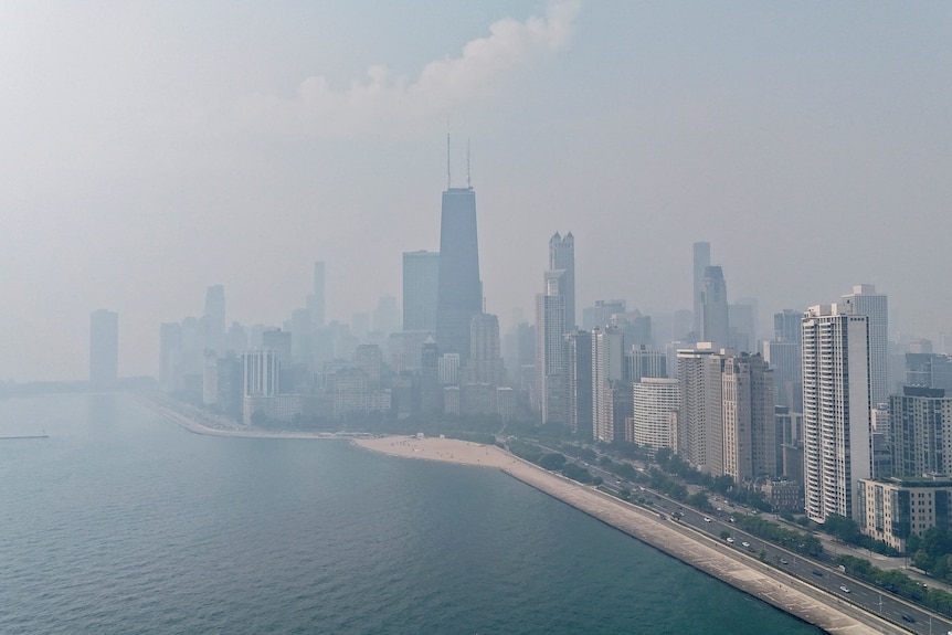 The high-rise skyline of Chicago, on the water-side, is shrouded in grey.