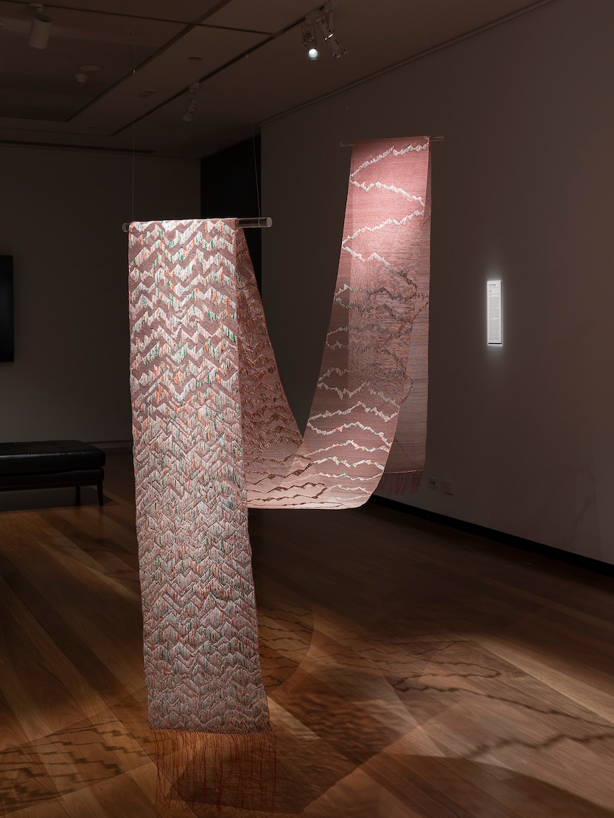 Thrums by Jacky Cheng, featuring a loop of upcycled Chinese calendar papers, Tyvek, nylon thread, kozo paper.