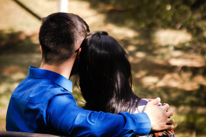 couple sitting on park bench