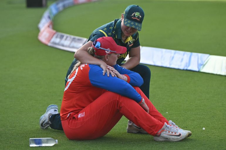 Australia's Georgia Voll consoles England's Sophie Ecclestone after the ICC Women's T20 cricket world cup 2026 final between Australia and England, at Lord's in London on July 5, 2026. Australia thrashed England by seven wickets to win the Women's T20 World Cup final at Lord's on Sunday. Victory gave Australia a record-extending seventh Women's T20 global title as they chased down a target of 151 with 17 balls to spare. (Photo by JUSTIN TALLIS / AFP)