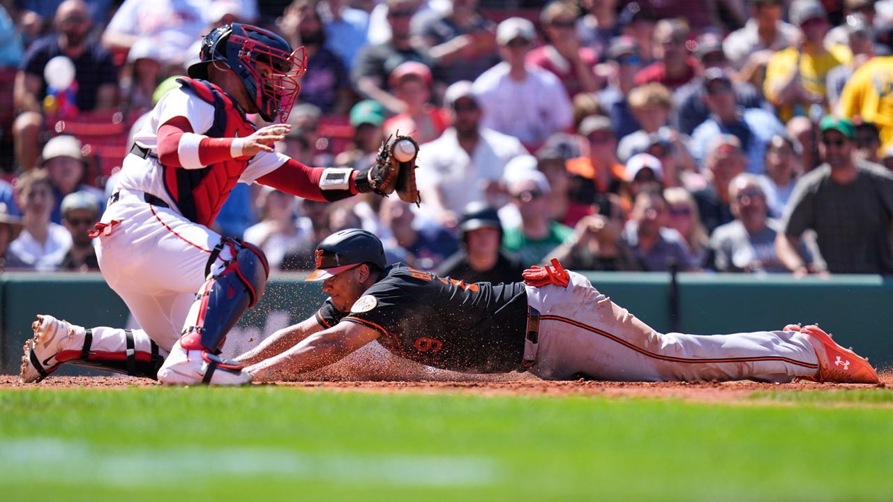 Baltimore Orioles' Samuel Basallo, right, beats the tag by Boston Red Sox's Carlos Narváez to score on a sacrifice by Colton Cowser during the fifth inning of a baseball game, Thursday, June 4, 2026, in Boston.