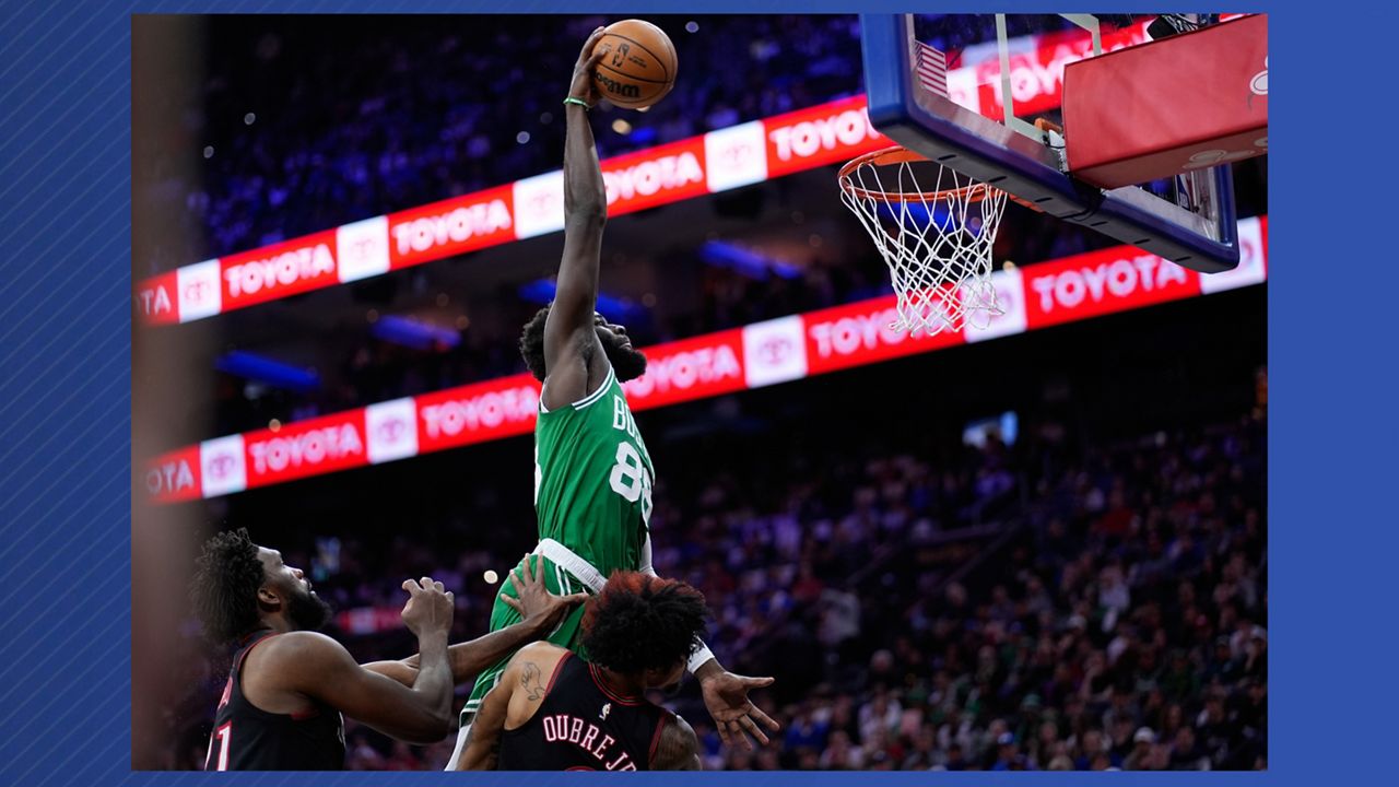 FILE - Boston Celtics' Neemias Queta, top, goes up for a dunk over Philadelphia 76ers' Kelly Oubre Jr., right, and Joel Embiid during the first half of Game 4 in a first-round NBA basketball playoffs series April 26, 2026, in Philadelphia. (AP Photo/Matt Slocum, File)