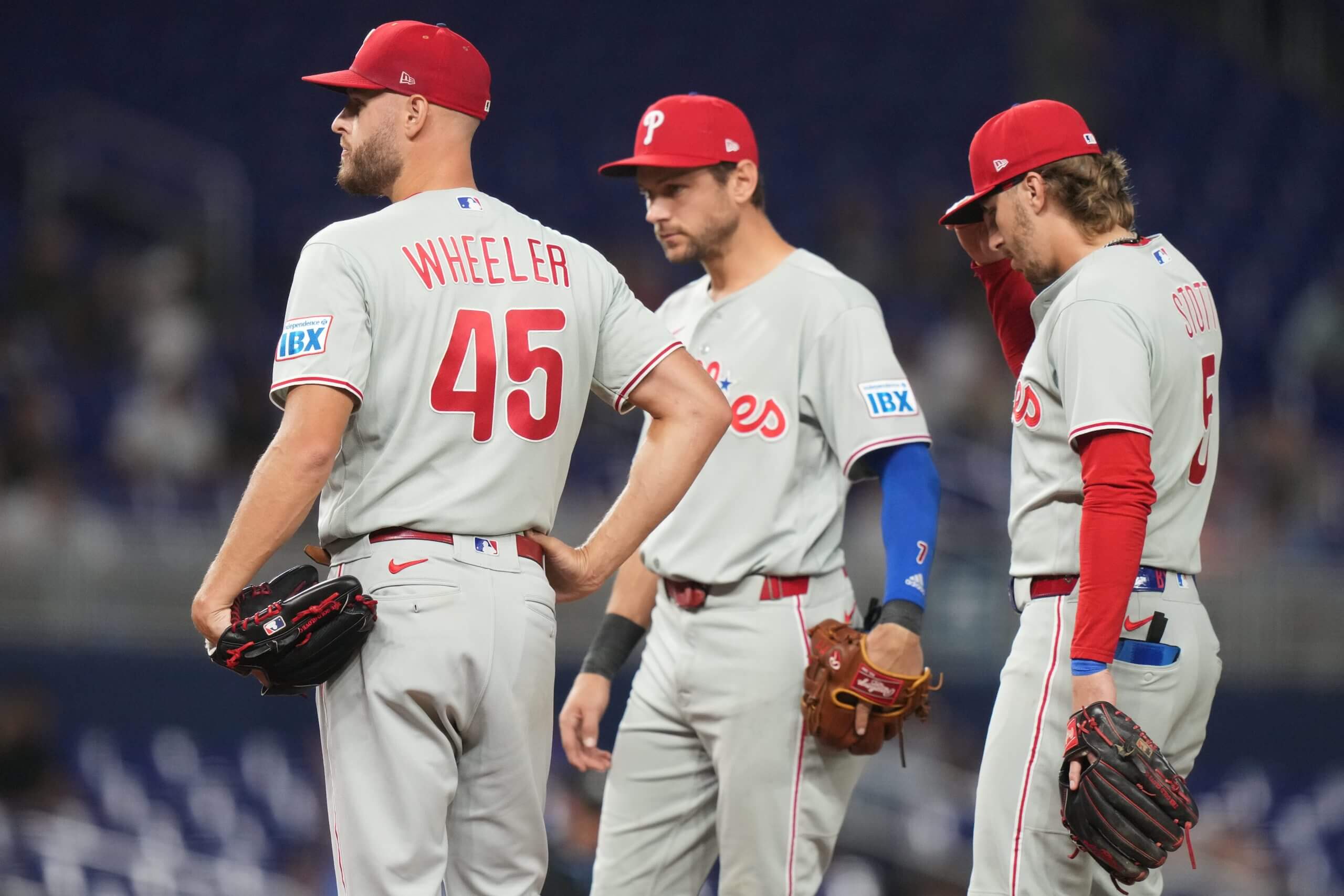 Philadelphia Phillies pitcher Zack Wheeler stands on the mound with his teammates. 