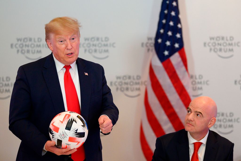 US President Donald Trump (L) holds a football as he speaks with FIFA President Gianni Infantino. (Photo by JIM WATSON/AFP via Getty Images)