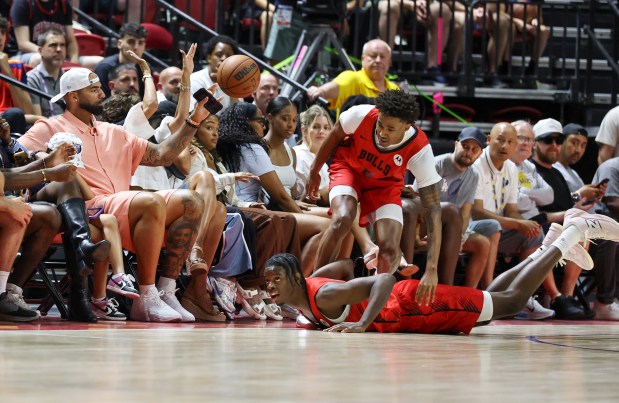 Former NBA player Carlos Boozer, left, reaches out to stop a ball as it goes out of bounds next to Bulls rookies Dailyn Swain, top, and Caleb Wilson in the first half of a summer league game against the Grizzlies on July 10, 2026, in Las Vegas. (Ethan Miller/Getty)