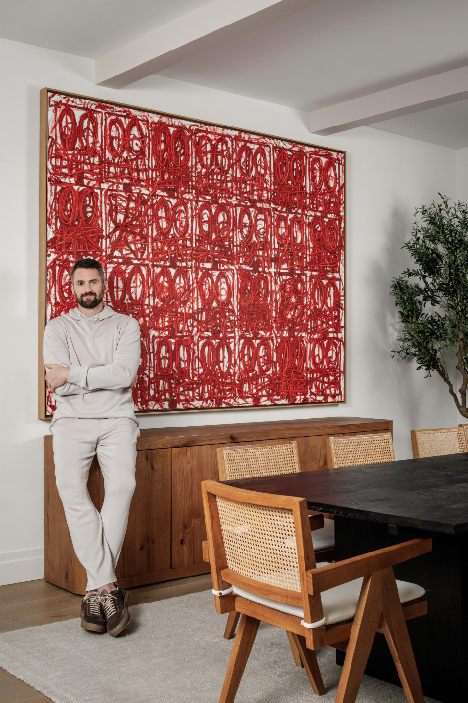 Kevin Love standing in front of a red Rashid Johnson painting