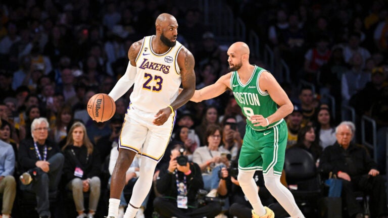 Los Angeles Lakers forward LeBron James dribbles as Boston Celtics guard Derrick White plays defense during the first half of an NBA basketball game, Sunday, Feb. 22, 2026, in Los Angeles.