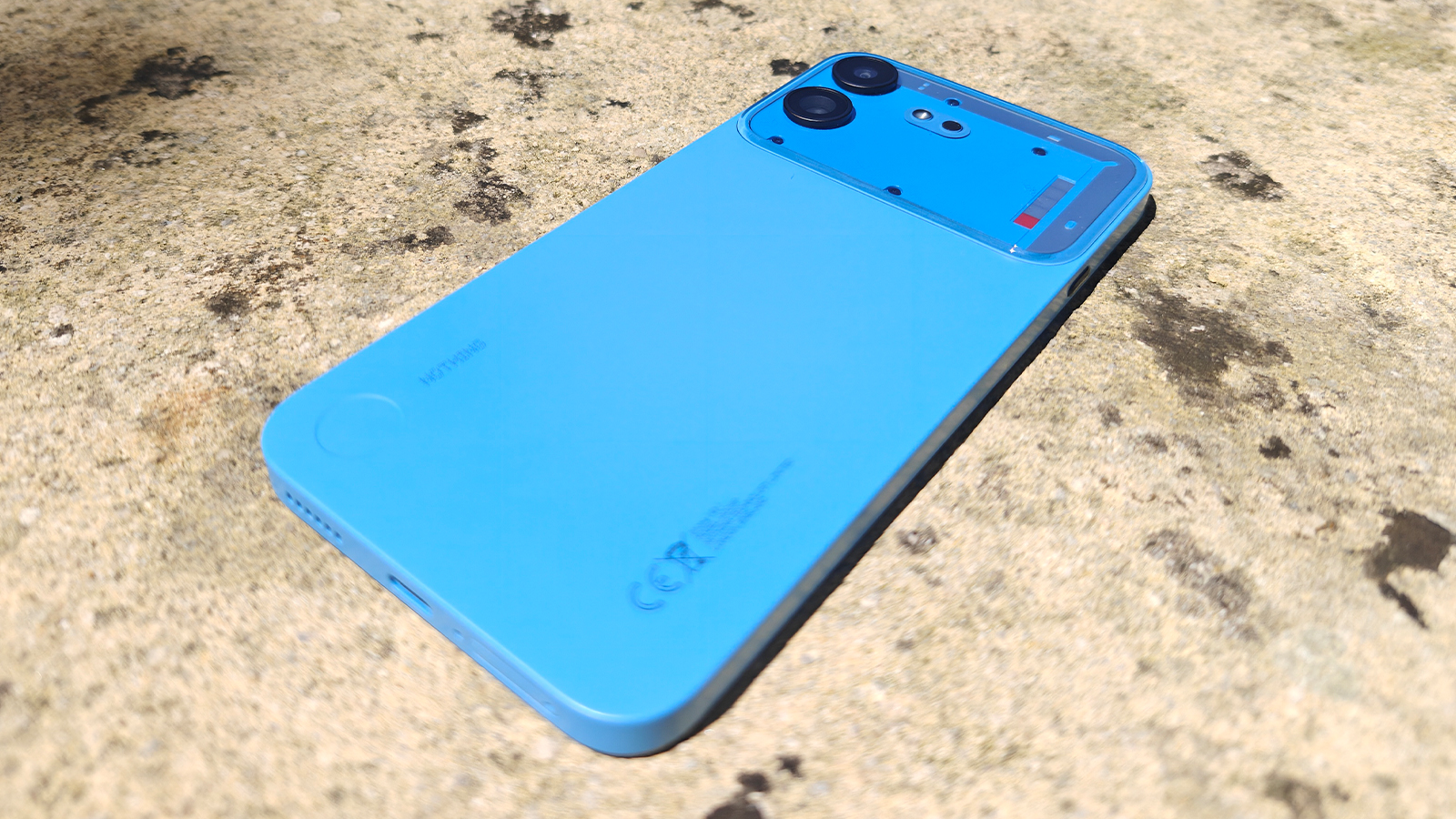 A blue phone on a stone