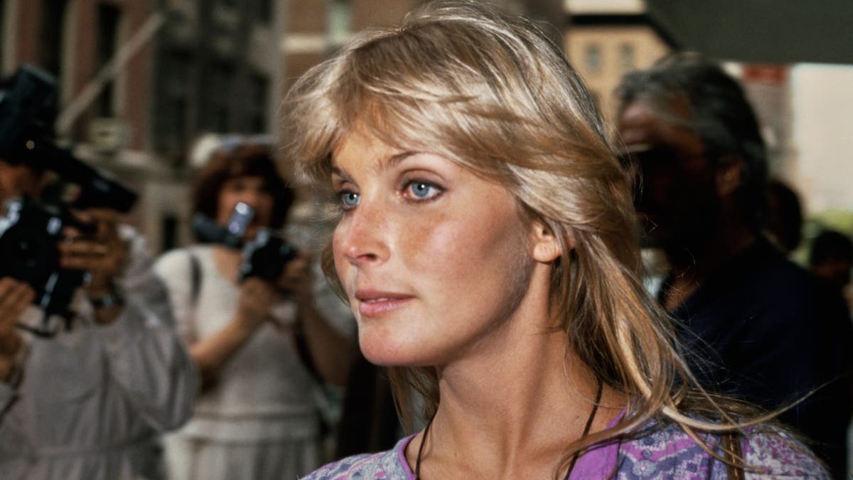American actress Bo Derek, wearing a purple patterned outfit, with photographers in the background, at La Guardia Airport, East Elmhurst, in the Queens borough of New York City, New York, 22nd July 1981. (Photo by Vinnie Zuffante/Getty Images)
