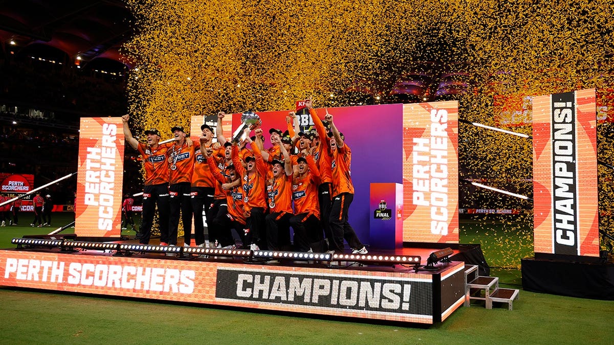 Perth Scorchers players celebrate while lifting the BBL Trophy at Perth Stadium.