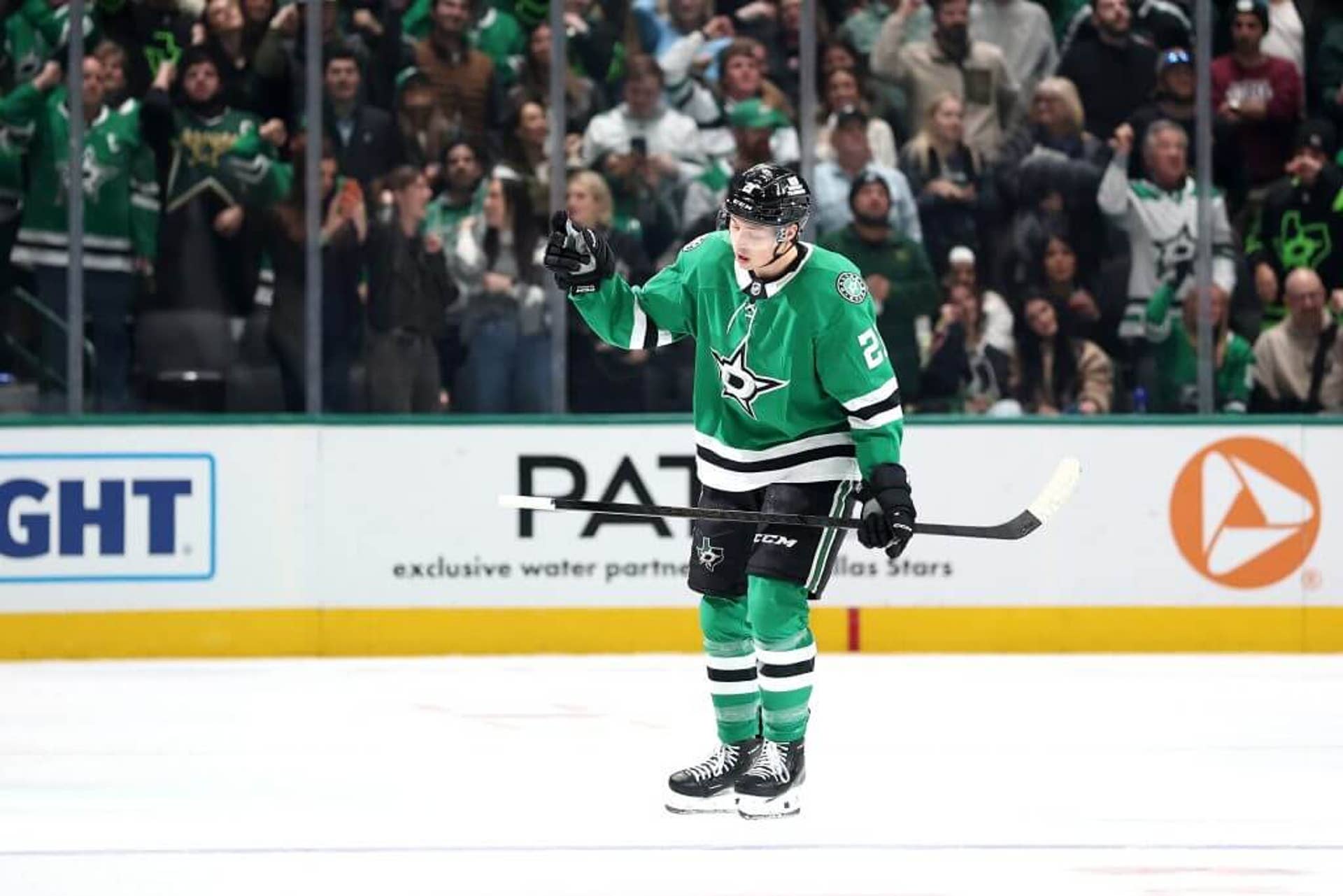 Jason Robertson lifts his hand in celebration after scoring a goal during a Dallas Stars game.