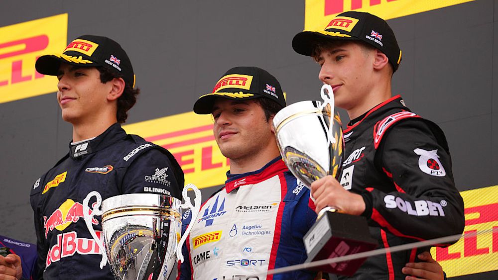 The top three celebrate on the podium after the race