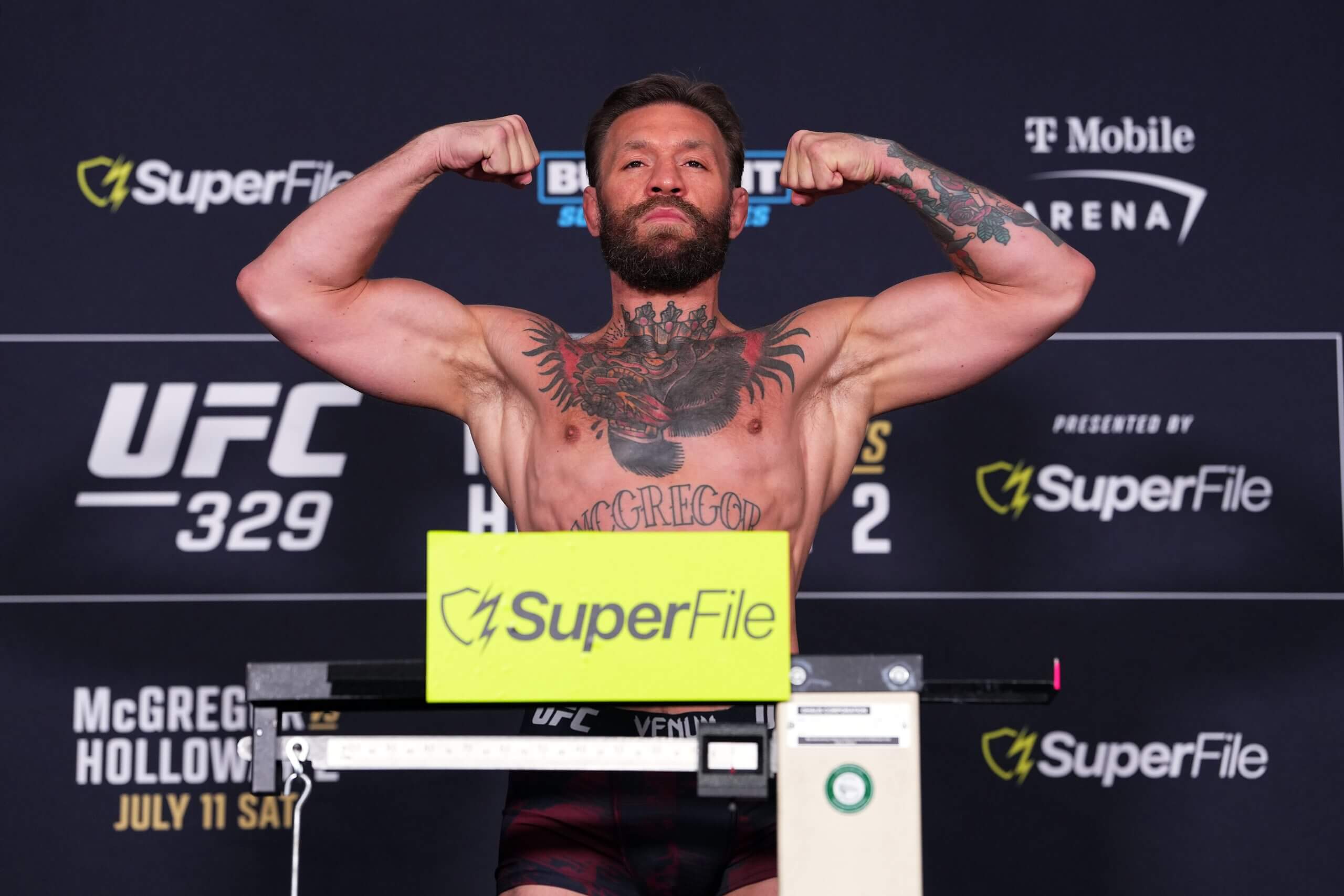 Conor McGregor poses on the scale at the weigh-in in Las Vegas