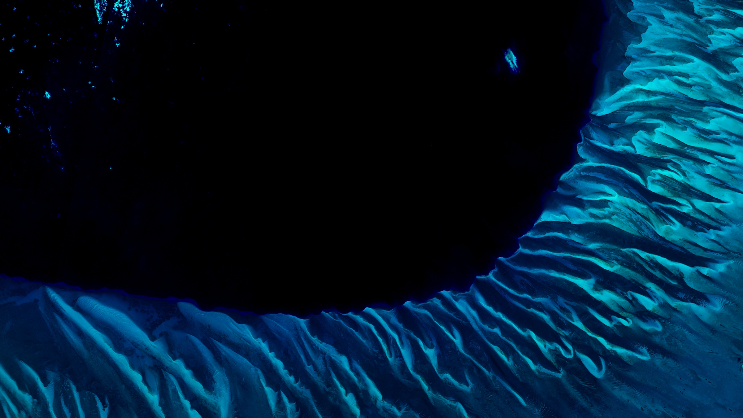 A satellite photo of the Great Bahama bank showing the point where it drops off into the dark "Tongue of the Ocean"