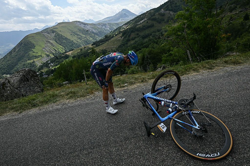 Soudal Quick-Step team's Belgian rider Ilan Van Wilder awaits technical assistance on the roadside during the 20th stage of the 113th edition of the Tour de France cycling race, 170,9 km between Le Bourg-d'Oisans and Alpe d'Huez in the French Alps, on July 25, 2026. (Photo by Loic VENANCE / AFP)
