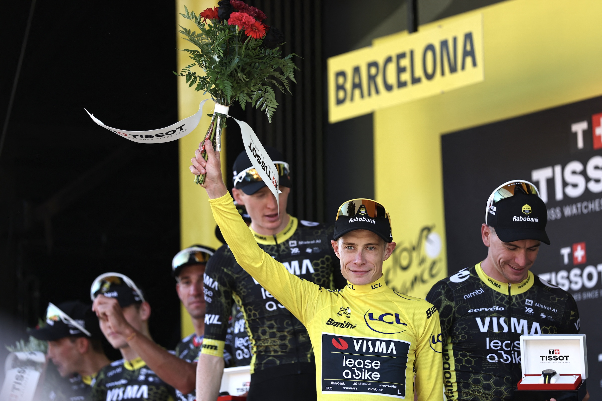 Team Visma | Lease a Bike's Danish rider Jonas Vingegaard celebrates on the podium with the overall leader's yellow jersey after the 1st stage of the 113th edition of the Tour de France cycling race, a 19 km team time trial stage in and around Barcelona in northeastern Spain, on July 4, 2026. (Photo by Anne-Christine POUJOULAT / AFP)