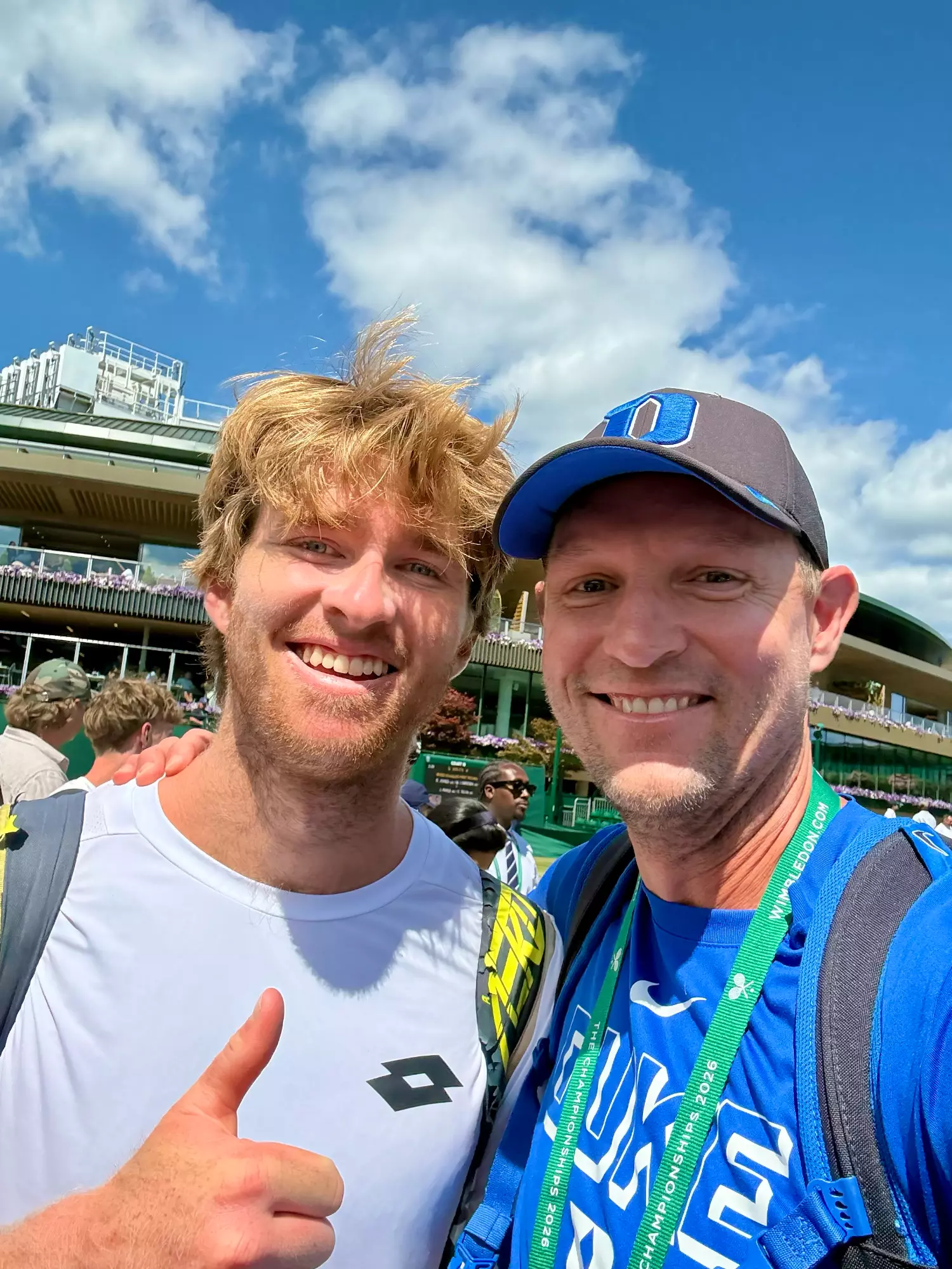 Former Duke men's tennis players Theo Winegar and Ramsey Smith, current Duke head coach, pose for a photo at Wimbledon after Winegar's second round doubles victory in 2026.