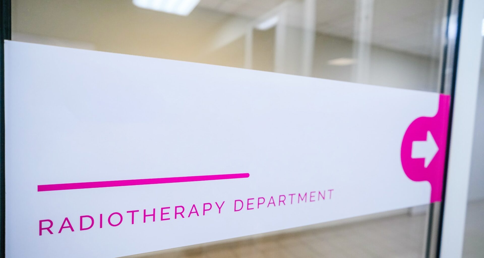 Sign "radiotherapy department" is visible in the hospital corridor. The sign indicates the direction of movement to the medical department of radiation therapy
