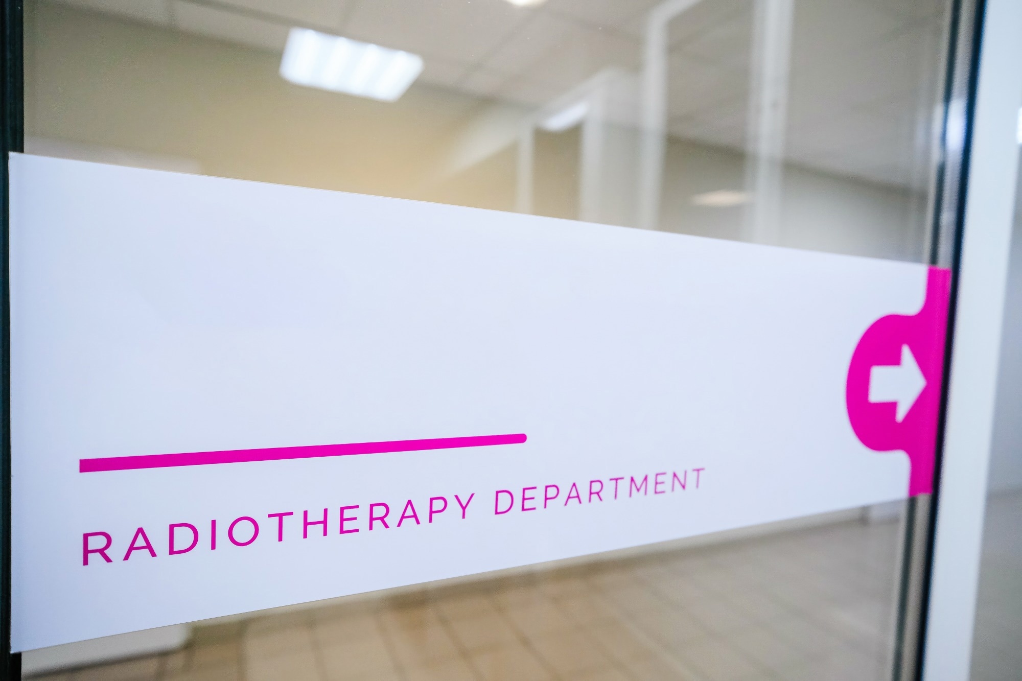 Sign "radiotherapy department" is visible in the hospital corridor. The sign indicates the direction of movement to the medical department of radiation therapy