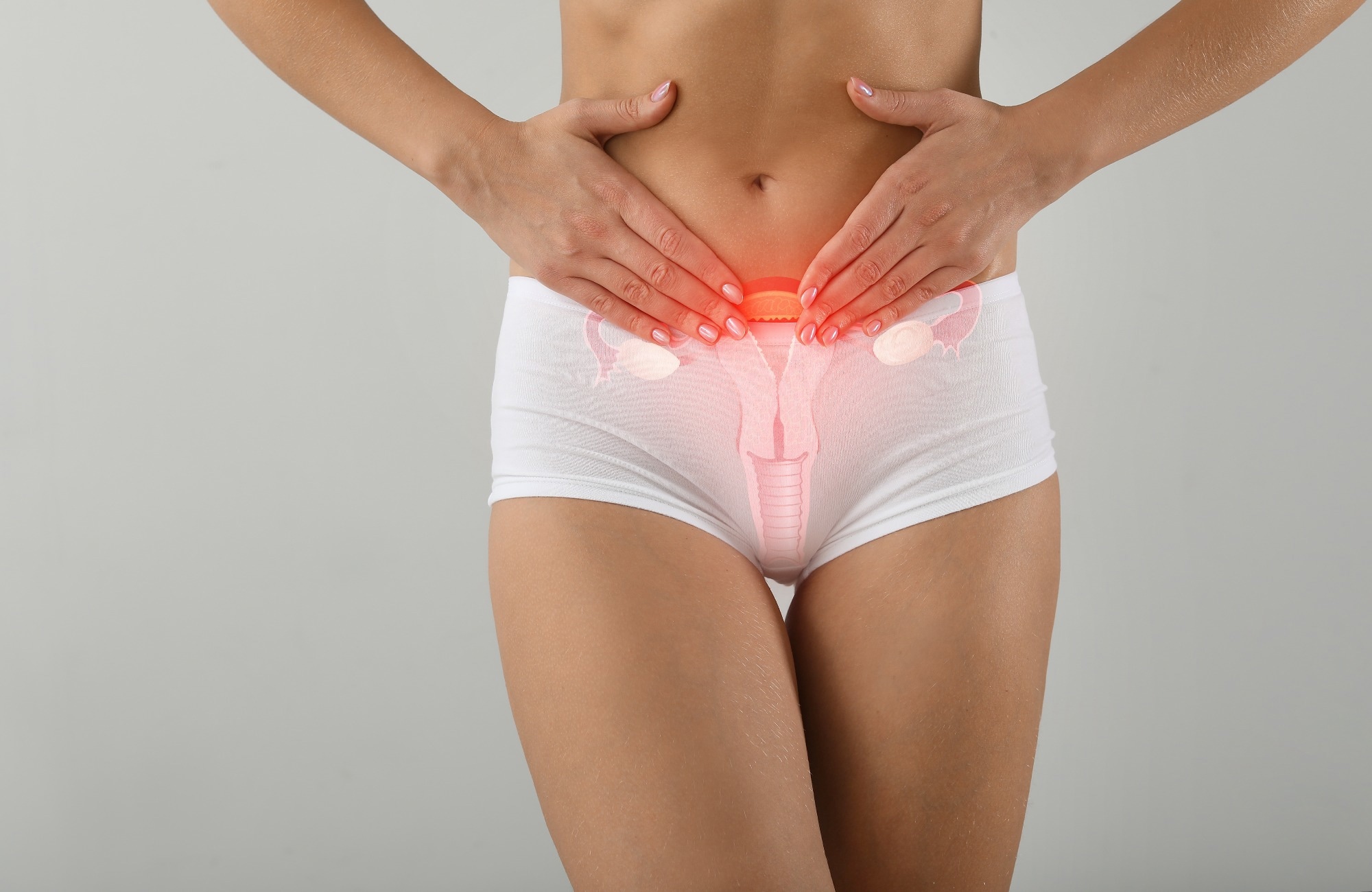 Young woman with drawing of reproductive system on light background. Gynecology concept
