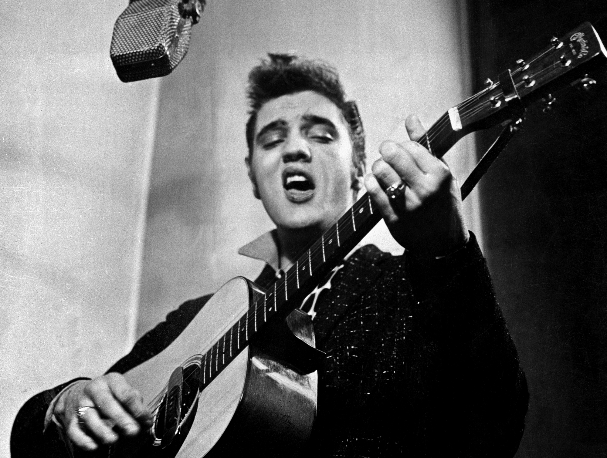 Close up of Elvis Presley playing guitar in 1956