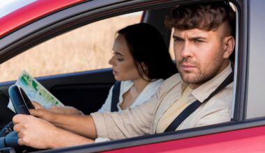 Man driving a car with a woman looking at a map