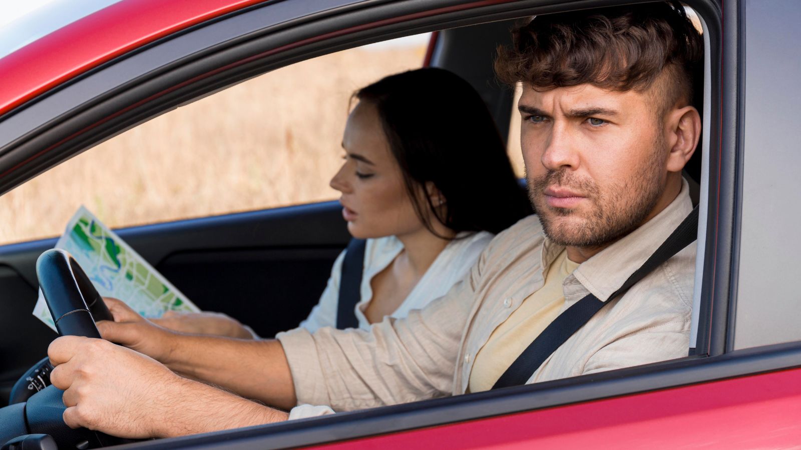 Man driving a car with a woman looking at a map