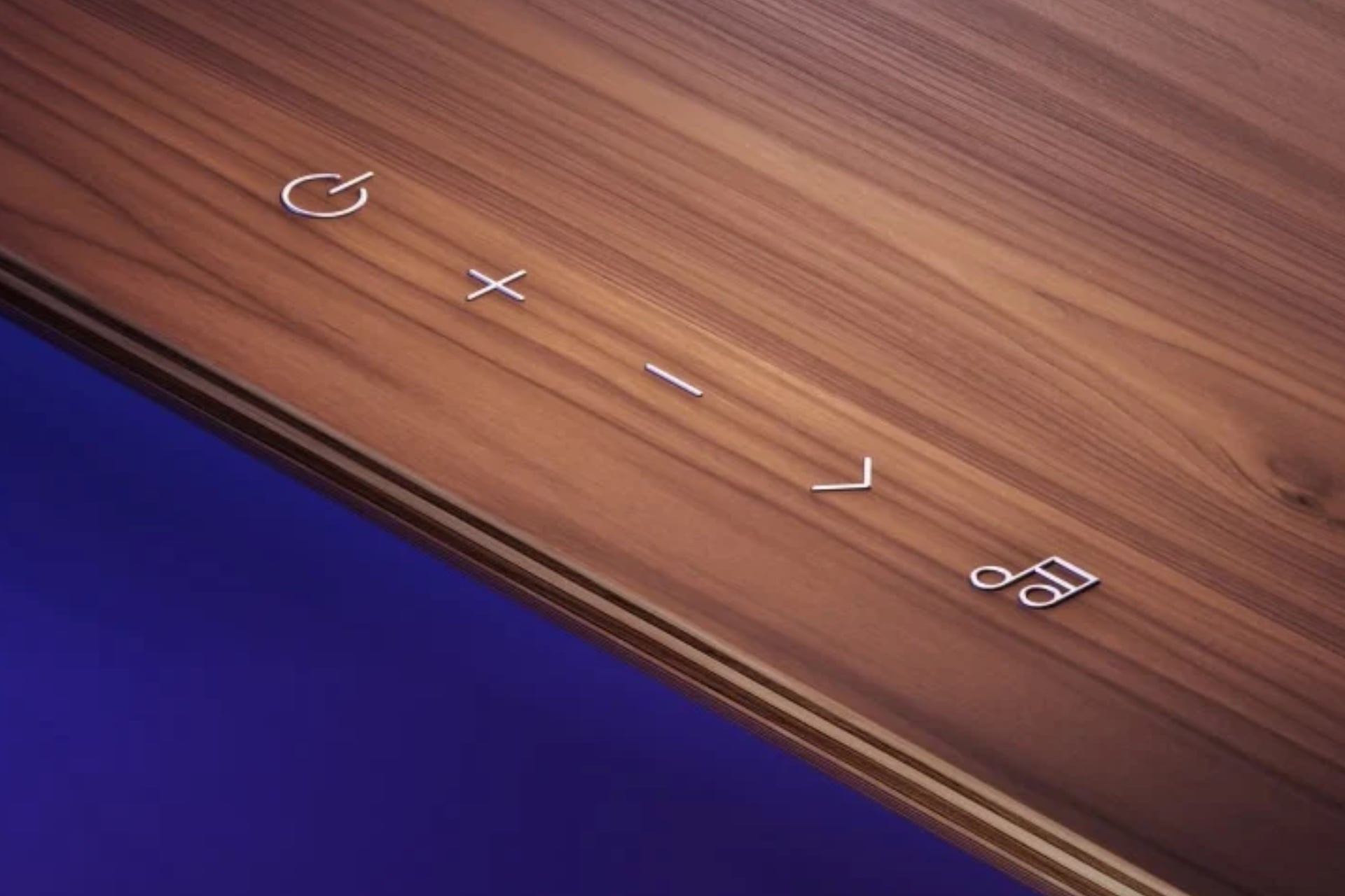 A closeup showing the stand's buttons. From left to right, they are a power button, plus button, minus button, right arrow button, and a musical note.