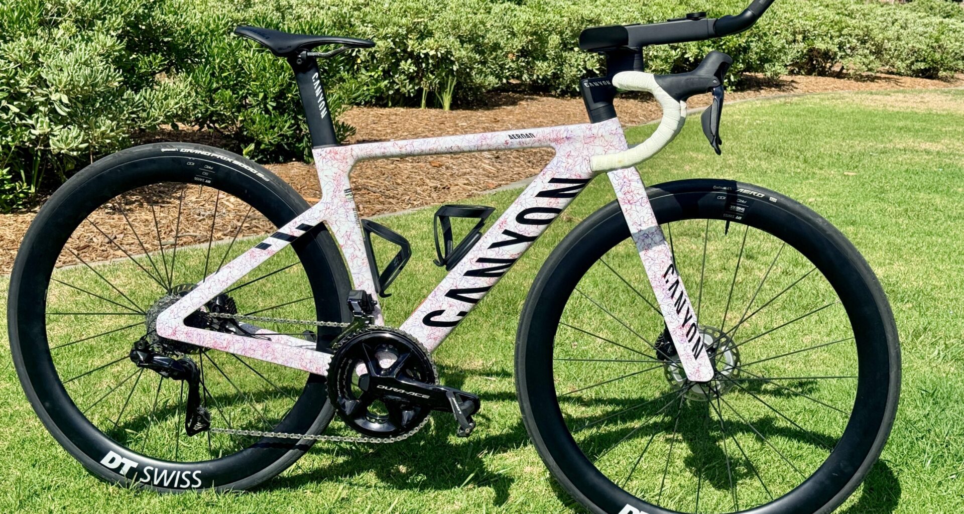 Canyon Aeroad CFR with Shimano Dura-Ace Di2 and GEAR GROOVE aero extensions, fitted with DT Swiss carbon wheels, photographed on grass