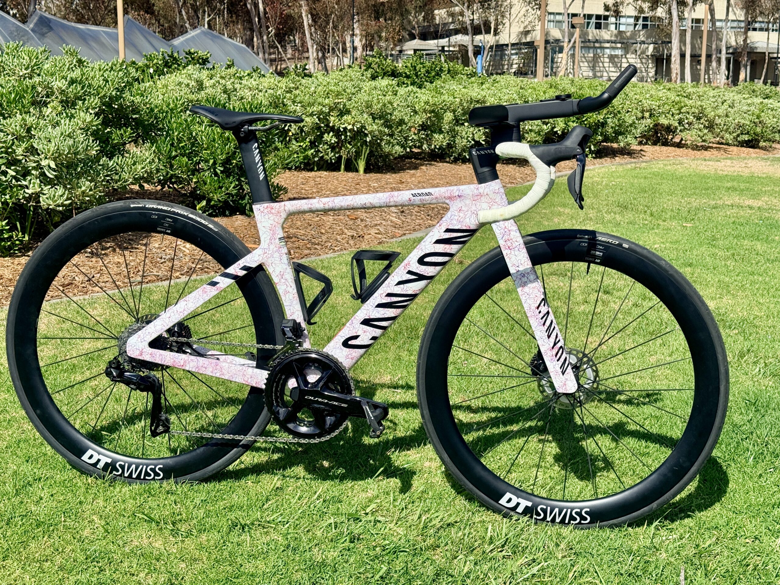 Canyon Aeroad CFR with Shimano Dura-Ace Di2 and GEAR GROOVE aero extensions, fitted with DT Swiss carbon wheels, photographed on grass