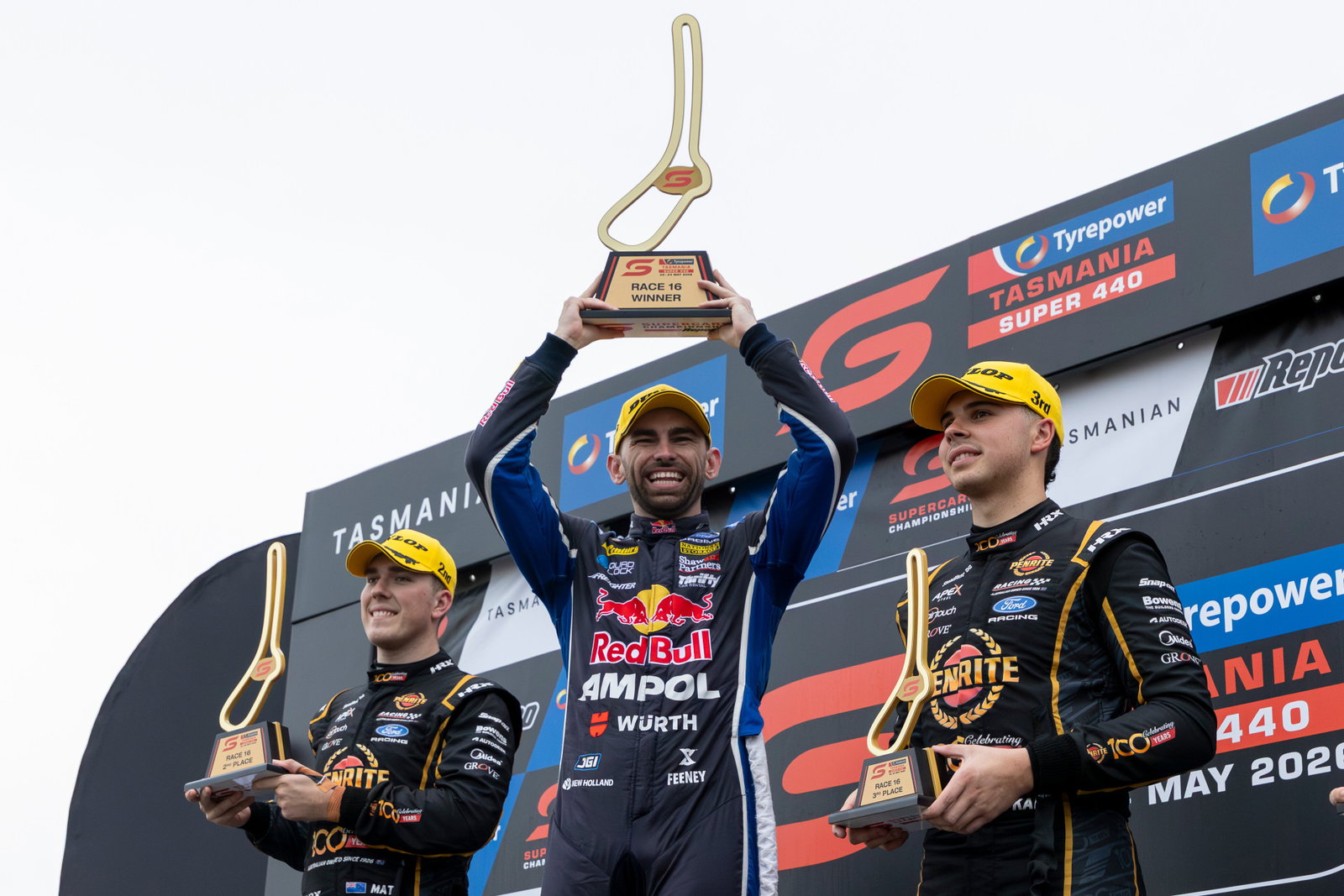 Broc Feeney (middle) celebrates on the podium with Kai Allen (right) and Matt Payne (left).