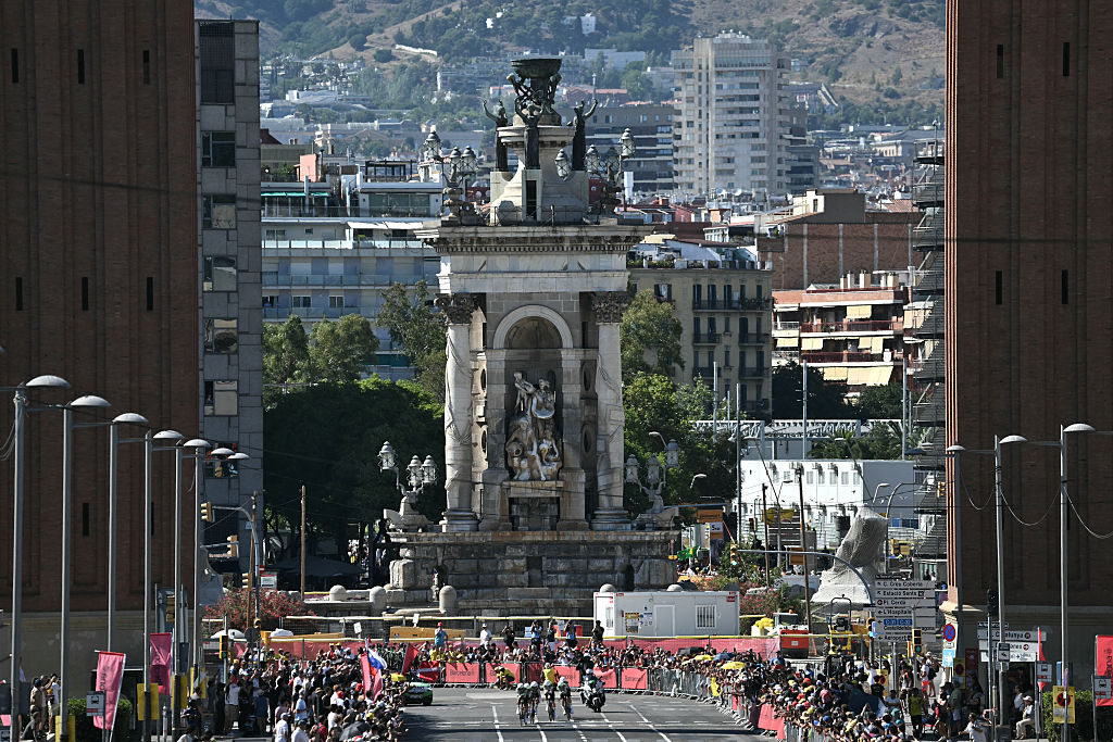 The team Caja Rural-Seguros RGA cycles next to the Venetian Towers at the Pla&ccedil;a d'Espanya during the 1st stage of the 113th edition of the Tour de France cycling race, a 19,6 km team time trial stage in and around Barcelona in northeastern Spain, on July 4, 2026. (Photo by Jeff PACHOUD / AFP)