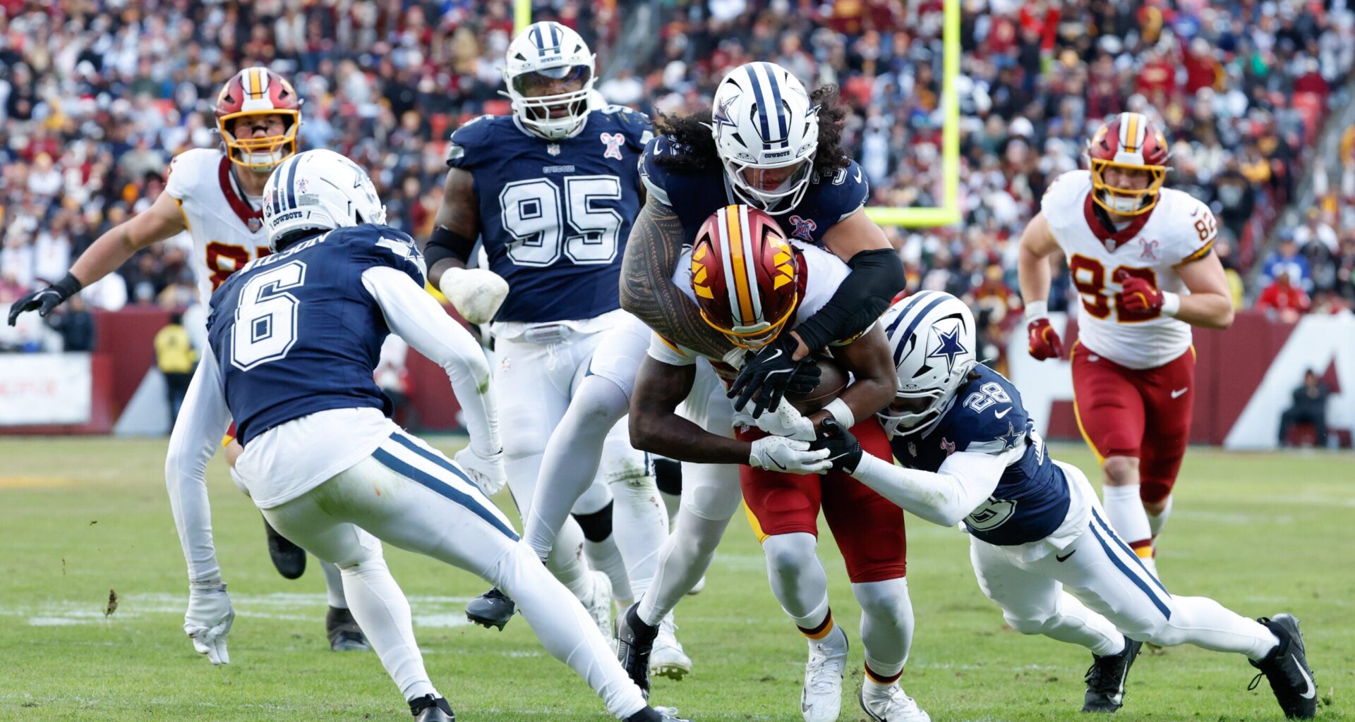 Dec 25, 2025; Landover, Maryland, USA; Dallas Cowboys linebacker Marist Liufau (35) and safety Malik Hooker (28) tackle Washington Commanders running back Jacory Croskey-Merritt (22) in the third quarter at Northwest Stadium.
