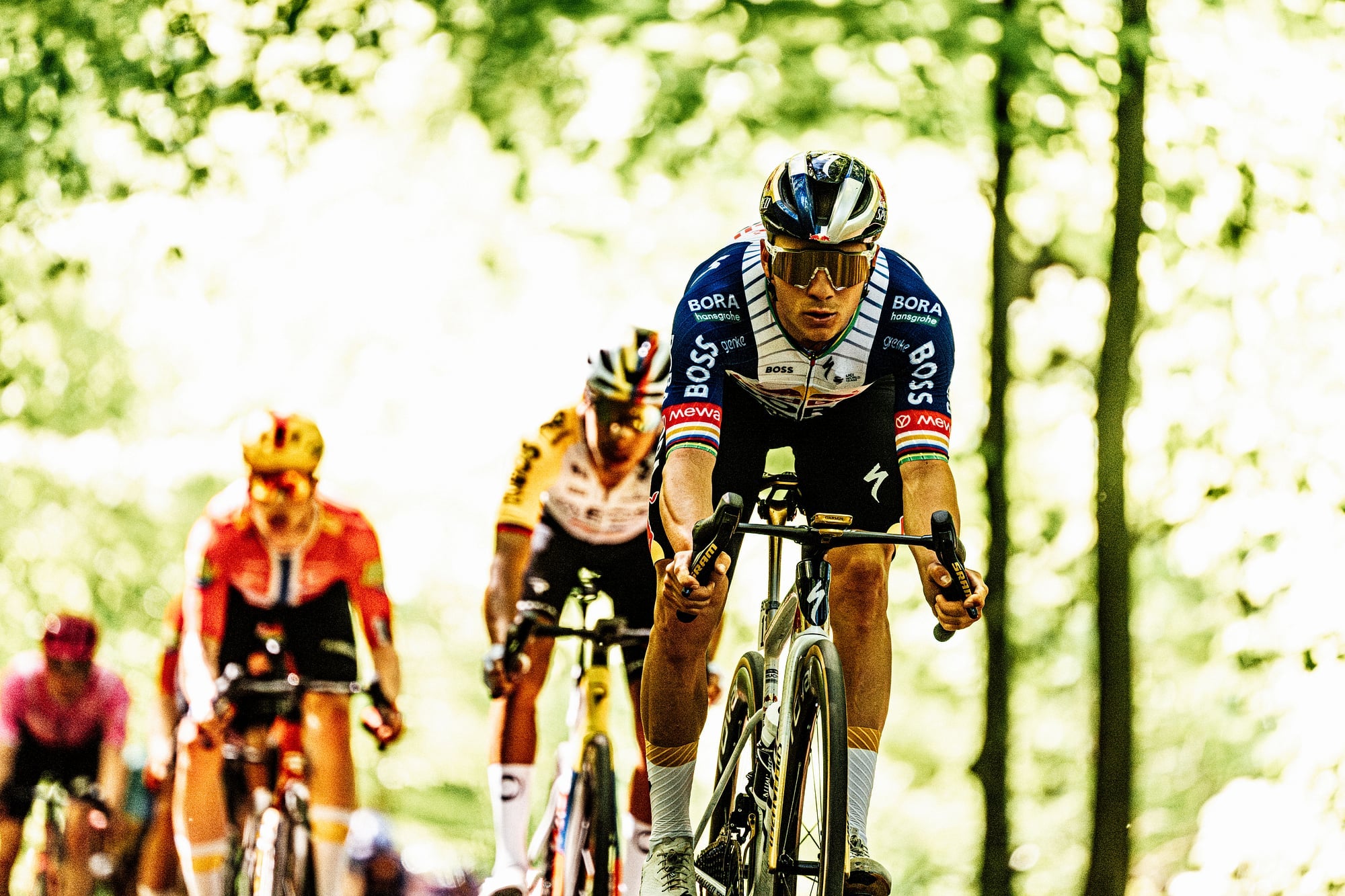 Remco Evenepoel attacks through a forest for Red Bull-BORA-hansgrohe