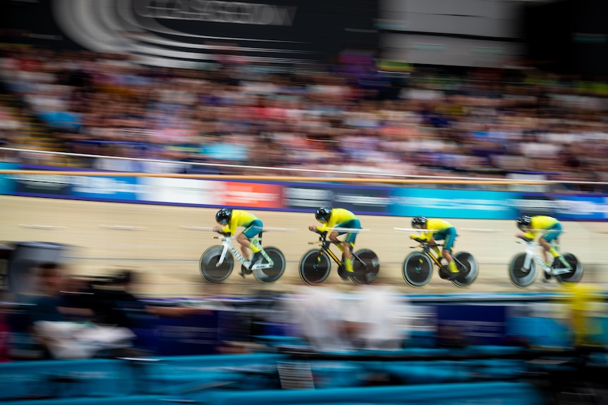 Cyclists speed around a velodrome