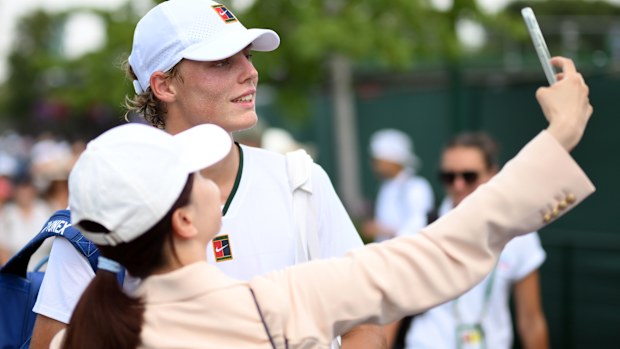 Hewitt poses for a photo with fans.