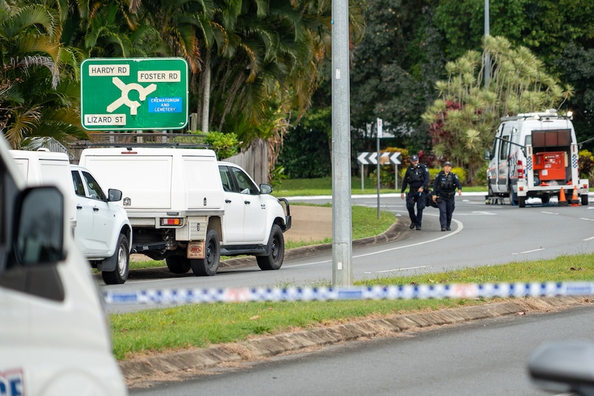 police cars and police tape on a tropical road