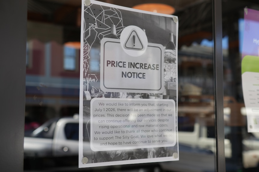 A sign in a cafe window which warns customers that prices will be increasing due to rising operational costs.